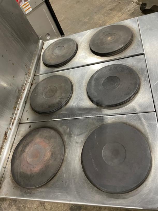 Commercial stainless steel six-burner hot plate stove, used condition, some wear. Ideal for high-volume cooking.