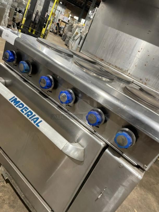 Stainless steel Imperial commercial stove with six burners, blue knobs, and oven door. Good condition. Marked "IMPERIAL."