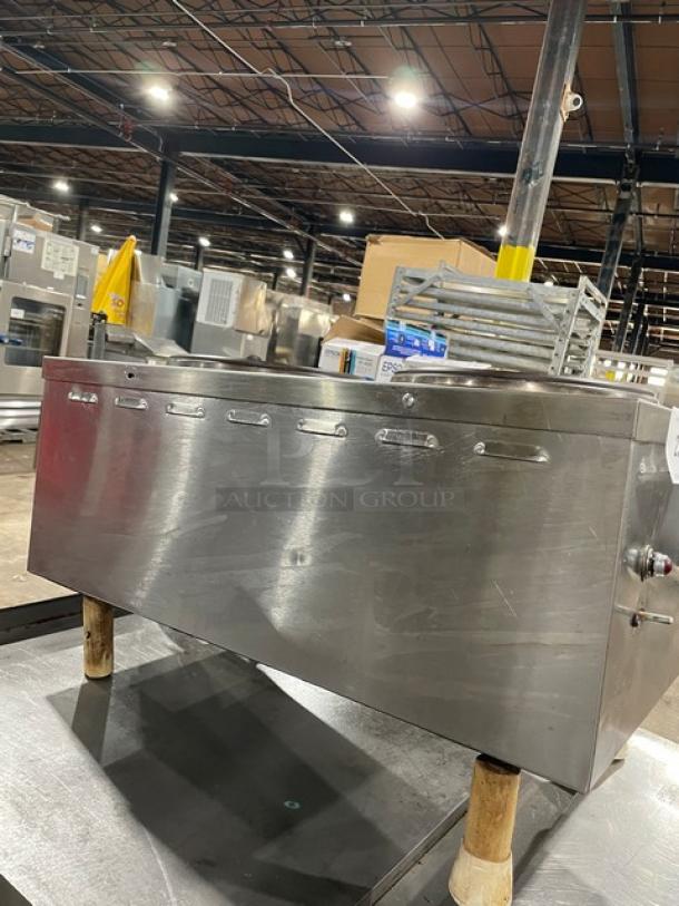 Stainless steel commercial food warmer, multiple compartments, sturdy legs, visible control knob, used condition, no visible labels.