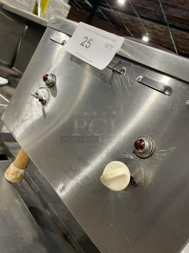 Stainless steel commercial kitchen equipment, with control knobs and wear scratches. Tag marked "25" for auction identification.