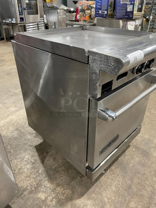 Stainless steel commercial oven with stovetop, showing slight wear. Model tag: "American Range." Good condition.