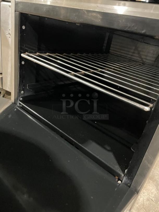 Commercial stainless steel oven, interior view with rack, in good condition. Ideal for heavy-duty kitchen use.