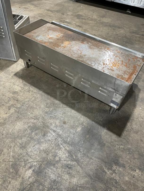 Metal griddle with rusted cooking surface, steel body, ventilation slots, and legs. Used condition, ideal for commercial use.