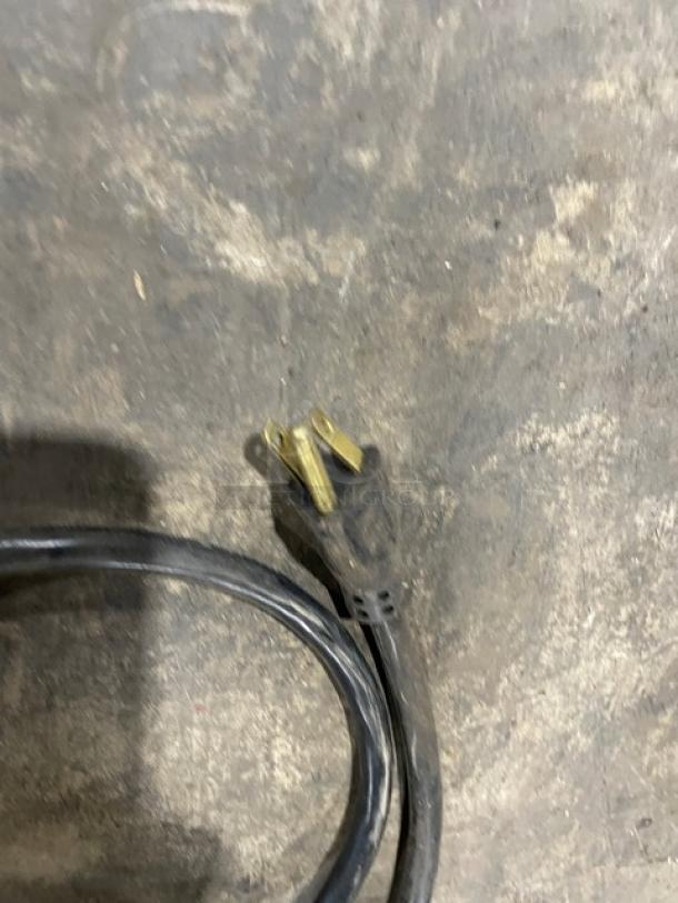 Black extension cord with a three-prong plug, visible wear on the cord. No labels or markings apparent.