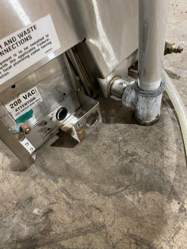 Industrial machine part, metal, with visible piping and connections. Marked 208 VAC, indicating voltage requirement. Used condition.