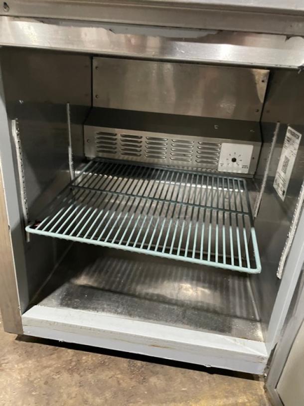 Commercial stainless steel warming cabinet with wire shelf, temperature control dial, and visible serial label, in good condition.