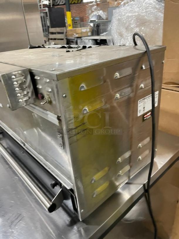 Commercial stainless steel equipment in used condition, showing visible scuffs. Attached power cord. Manufacturer label present but unreadable.