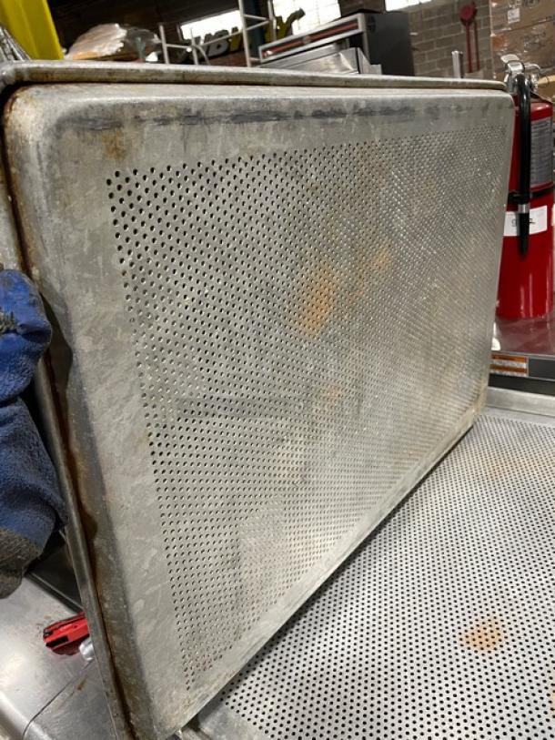 Perforated metal sheet in used condition with visible rust spots, suitable for industrial or architectural use.