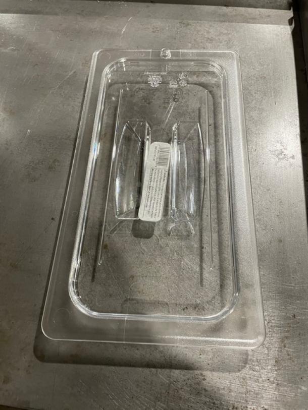 Clear plastic food pan lid with handles, featuring a manufacturer label in the center. In excellent condition.