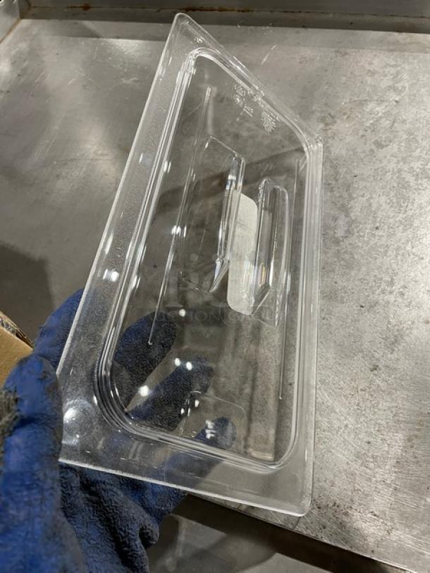 Transparent plastic food container lid, rectangular, gently used, visible handle, no labels or markings.