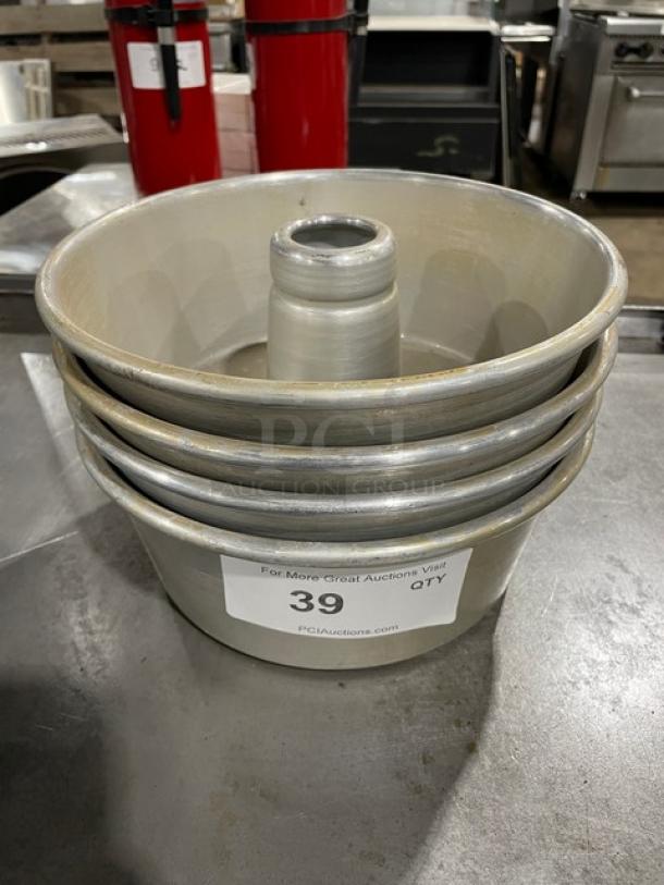 Set of four metal cake pans in used condition, each with a central tube. Label shows item number 39 and auction website.