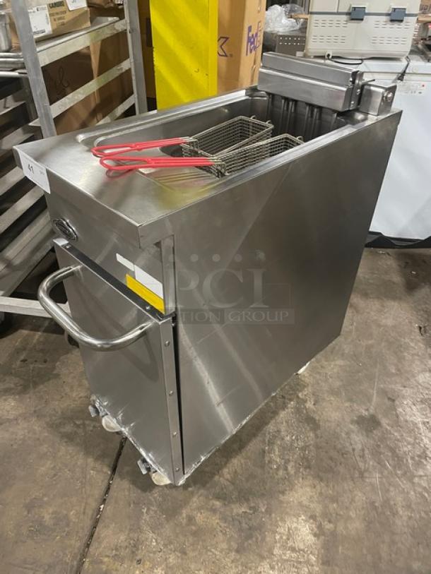 Stainless steel commercial deep fryer with twin baskets, used condition, handle for mobility, auction item label visible.