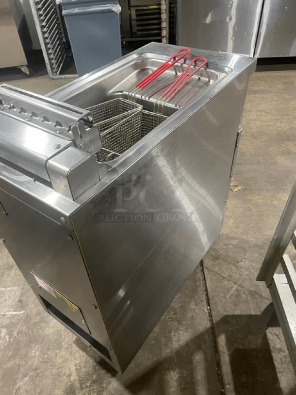 Commercial deep fryer with twin baskets, stainless steel, good condition. Includes basket hangers and frying guides.