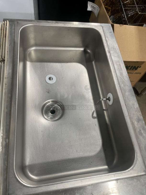 Stainless steel commercial sink basin, rectangular shape, single drain, lightly used condition, visible use marks.