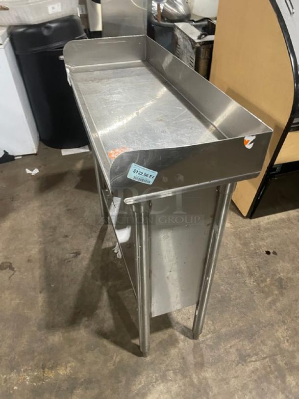 Stainless steel prep table with raised edges, in fair condition. Price tag shows "$12.98 EA". Suitable for kitchen use.