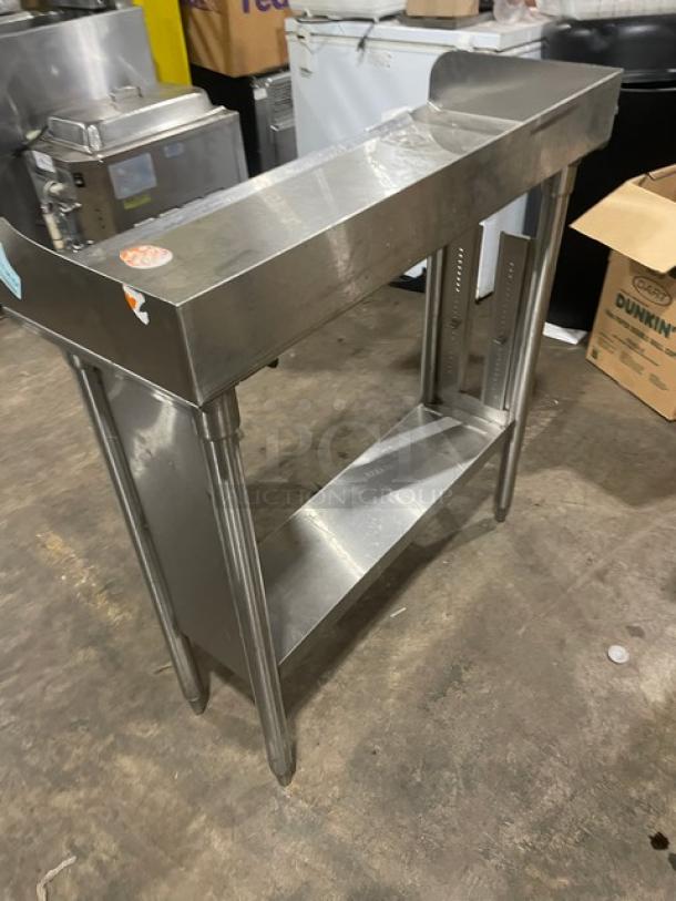 Stainless steel commercial kitchen prep table with undershelf, good condition, minor surface scratches, sturdy build.