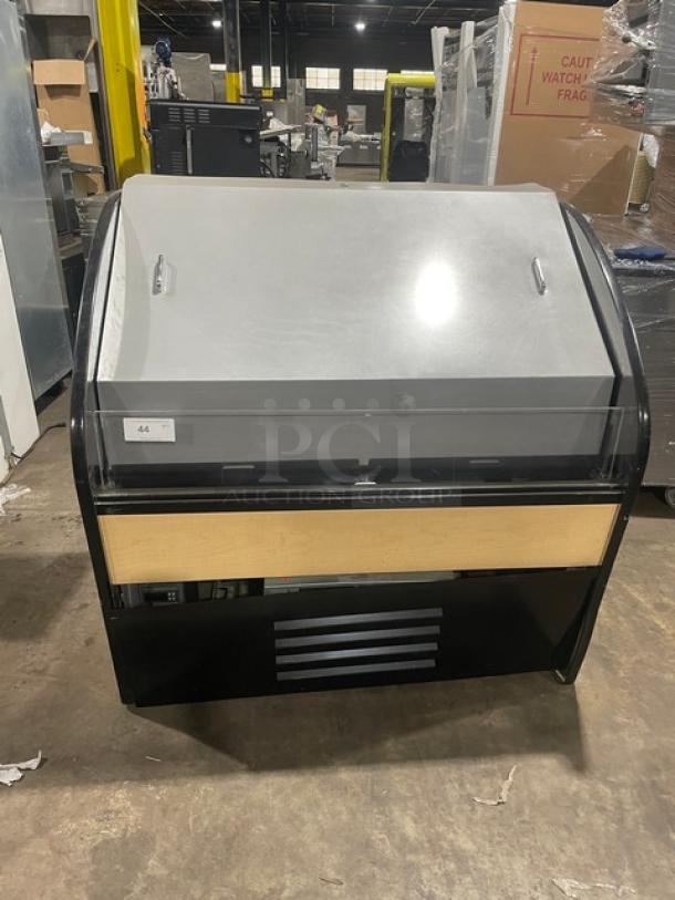 Commercial refrigerated display case with a glass front and metal top, tag reading "44," in used condition, suitable for retail use.