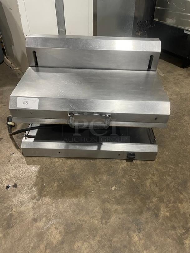 Stainless steel commercial sandwich press with dual heated plates, front handle, and power cable. Auction lot number 45.