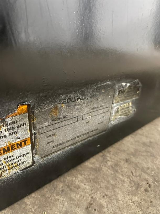 Metal equipment panel with faded labels showing fields for model, volts, and amps. Labels are worn and partially legible.