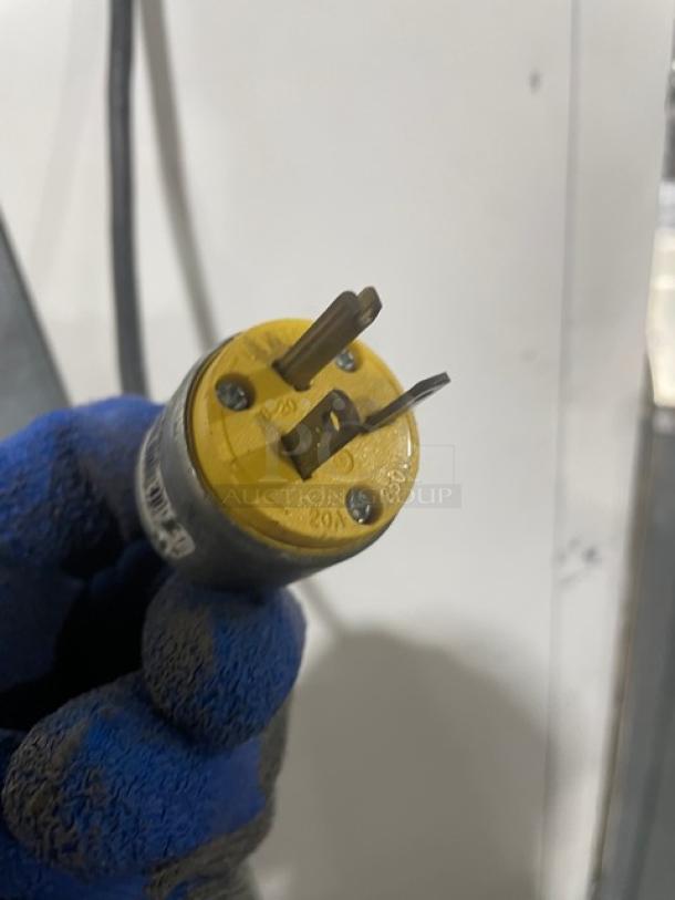 Yellow industrial power plug rated 20A 250V, three prong, used condition, visible markings for power rating.