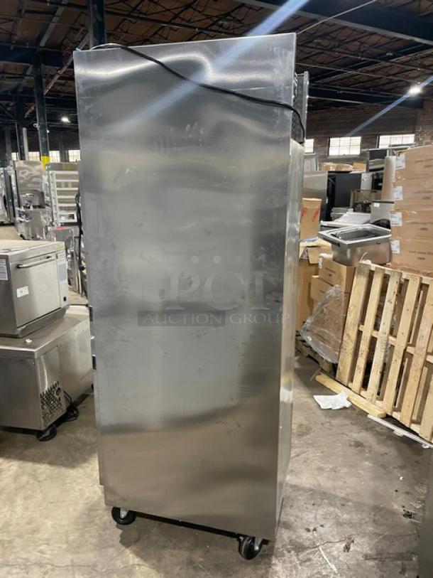 Commercial stainless steel refrigerator on wheels, used condition, basic model with no visible branding or markings.