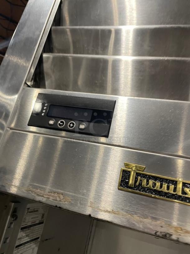 Stainless steel commercial oven with digital controls and a Traulsen logo. Minor wear visible on the exterior.