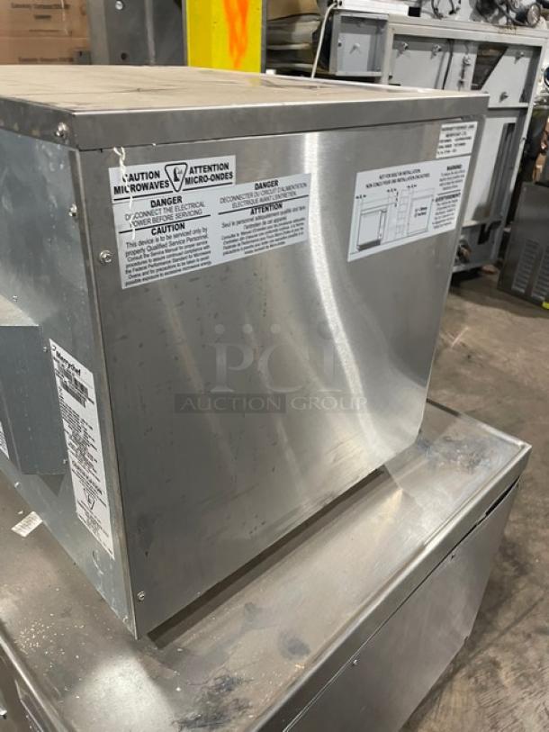 Commercial stainless steel microwave with warning labels; used condition; model details and electrical specifications noted.