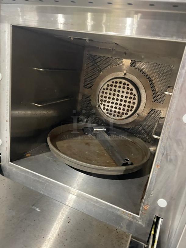 Industrial oven interior with stainless steel finish, showing a circular fan and rotatable tray. Well-maintained condition.