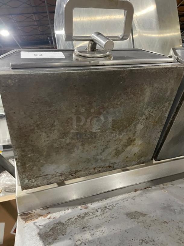 Commercial-grade metal deep fryer with visible rust and wear, features a lid with a handle. Auction tag visible on top.