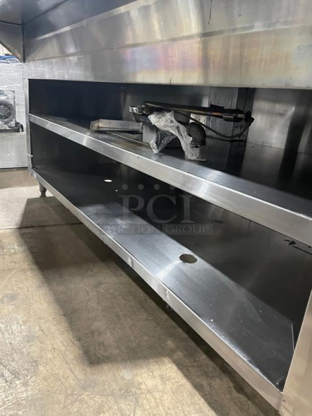 Stainless steel commercial kitchen shelving unit with two tiers, lightly used, features mounted equipment, 72x24 inches.