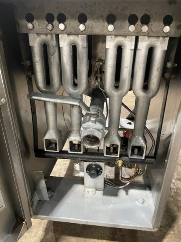 Industrial heater burner assembly with metal pipes, control valve, and wiring. Signs of use with minor discoloration.