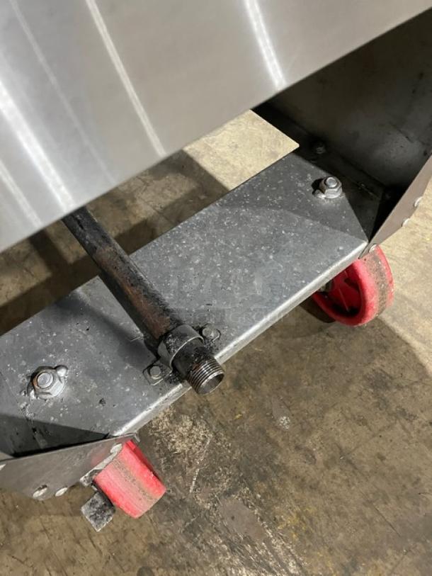Industrial metal cart with red caster wheels, showing sturdy construction. Visible bolts and metal surfaces in used condition.