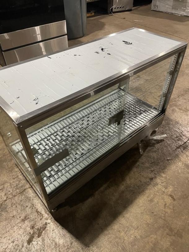 Glass-front display case with metal frame, sliding doors, and adjustable shelves. Signs of wear on top surface.