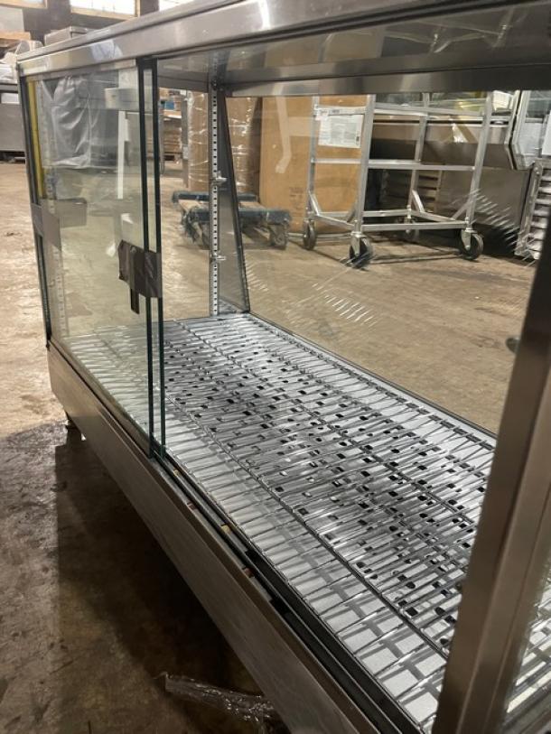 Stainless steel display case with glass panels, sliding doors, and metal shelves. Clean condition, suitable for commercial use.