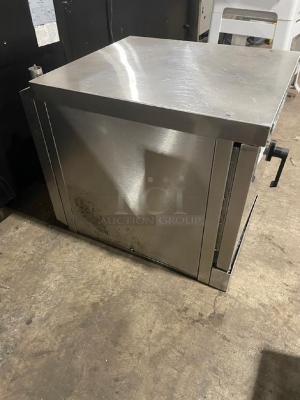 Stainless steel warming cabinet with door handle, showing signs of wear and use, ideal for commercial kitchens.