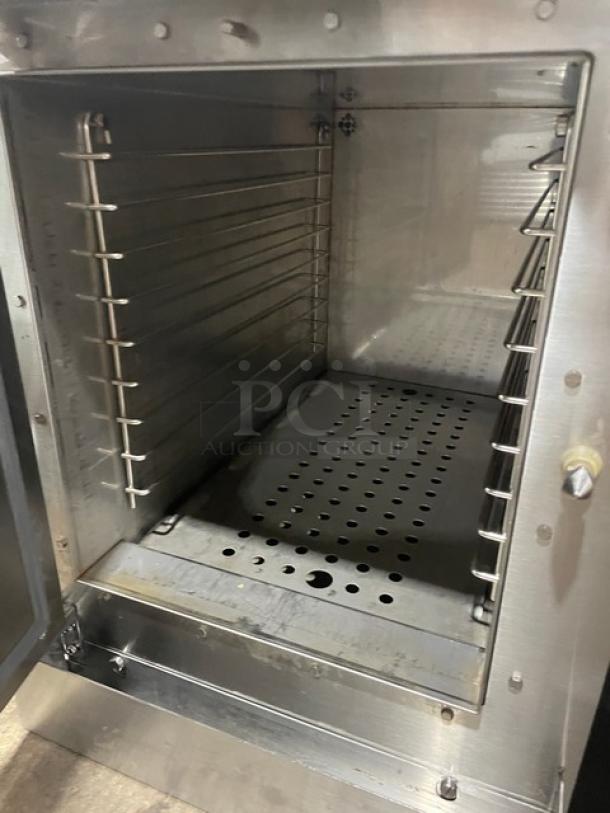Stainless steel commercial oven interior, multiple adjustable racks, perforated bottom, excellent condition, durable design.