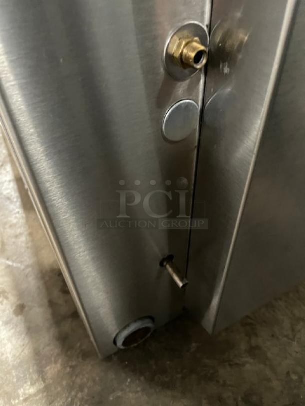 Stainless steel appliance with brass fitting, showing minor wear. Includes visible bolts and connector. Suitable for parts or repair.