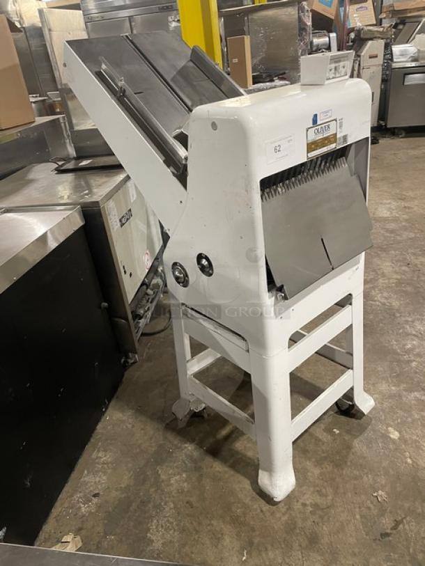 White Oliver bread slicer, model 777-N, in used condition. Features sharp blades and a sturdy frame. Visible model label.