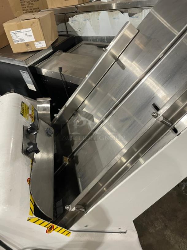 Industrial metal slicer with stainless steel blades, adjustable knobs, and safety markings. Appears in good condition.