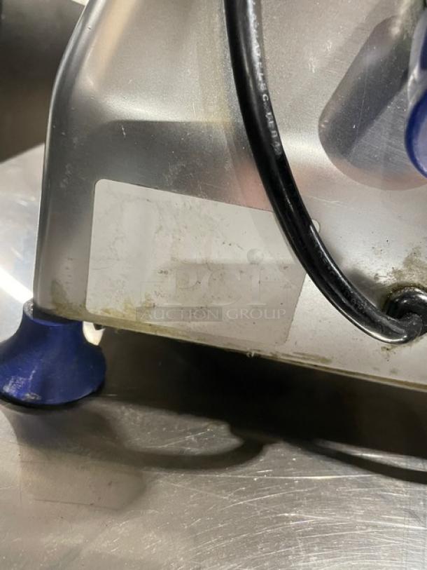 Silver appliance base with blue rubber feet, power cord, and a blank white label. Slight wear and discoloration visible.