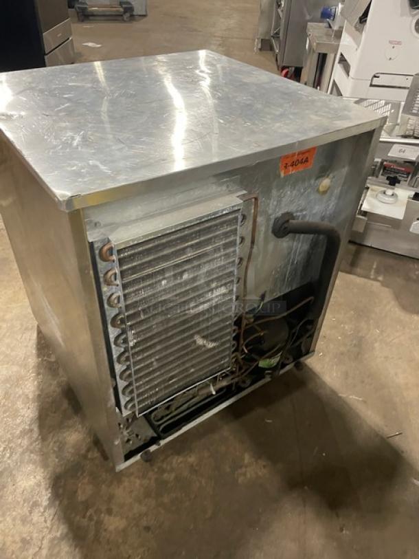 Commercial refrigeration unit in used condition, metal exterior, exposed cooling coils, and labeled "R-404A" for refrigerant type.