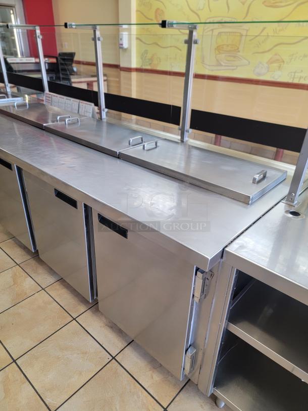 Wasserstrom 21-Foot Refrigerated Prep Table with Cold Food Wells - Massive Capacity! Revolutionize your kitchen's prep and cold storage! We're offering an impressive 21-foot Refrigerated Prep Table with integrated Cold Food Wells, the ultimate solution for high-volume sandwich, salad, pizza, or assembly lines. This is a must-have for large restaurants, delis, catering operations, or institutional kitchens that demand efficiency and ample refrigerated storage. See Video in Description Below 👇*BUYER MUST REMOVE - NO SHIPPING OR HANDLING AVAILABLE* - Image 3 of 9