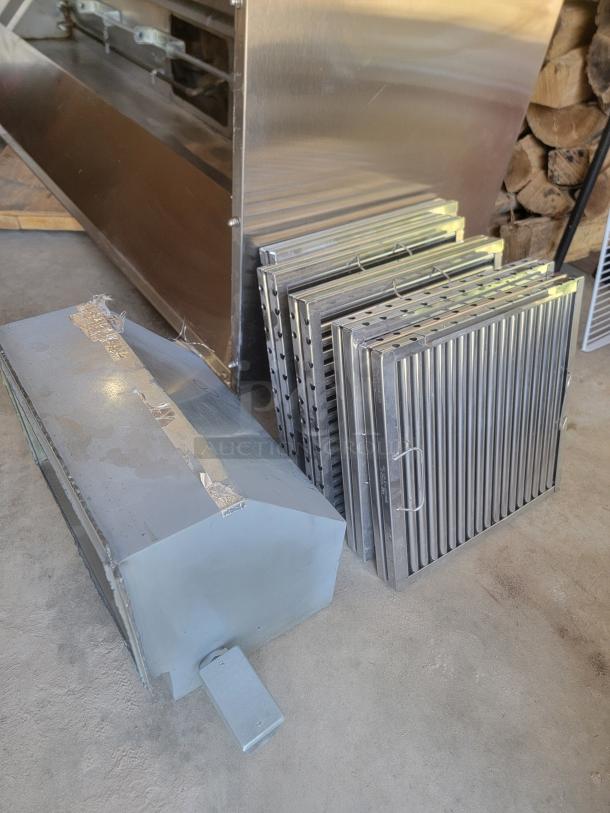 Commercial metal cooking grates and ducting in good condition. Stackable grills with handles; duct shows tape and wear.