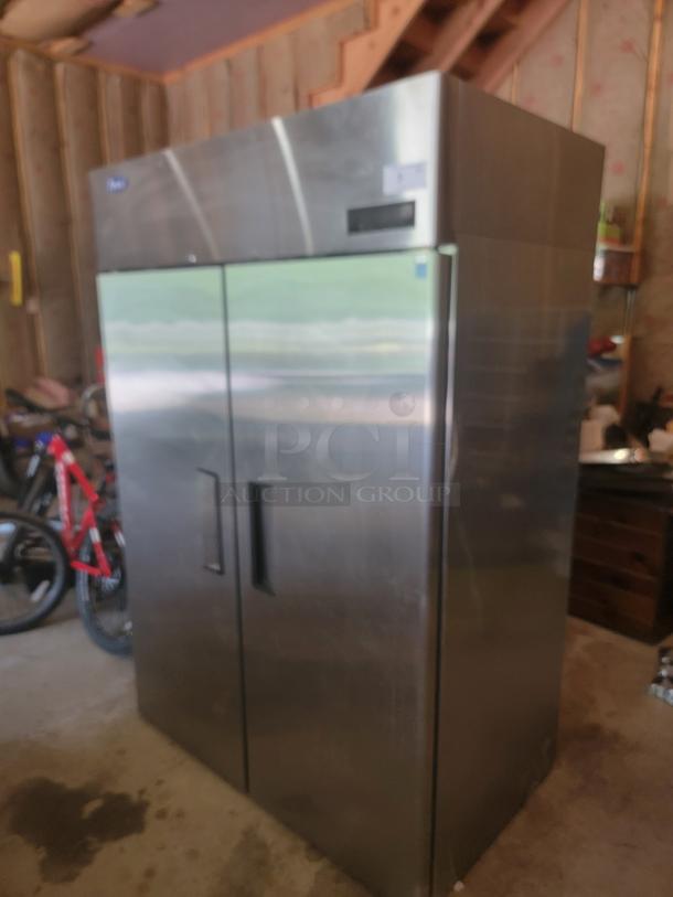 Commercial stainless steel double-door refrigerator, lightly used, features digital display, handle dents visible.