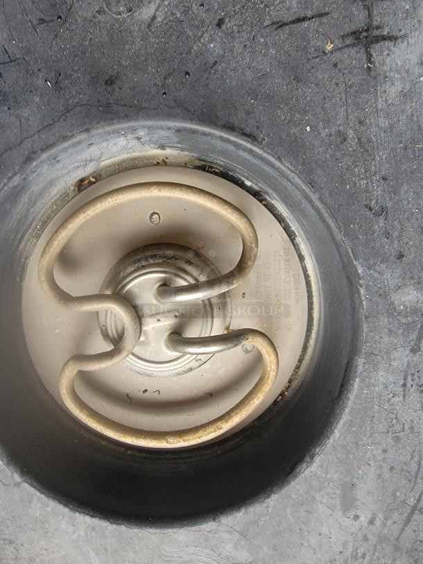 Electric stove coil burner in used condition, with visible metal wear. Markings indicate electrical caution and usage instructions.