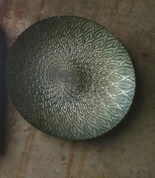 Intricately patterned metallic bowl with a peacock feather design, in excellent condition, highlighting reflective textures.