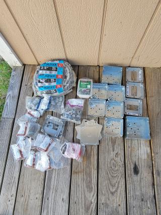 Collection of electrical supplies, including Alflex 3/8" cables, metal boxes, and plastic fittings on a wooden surface.