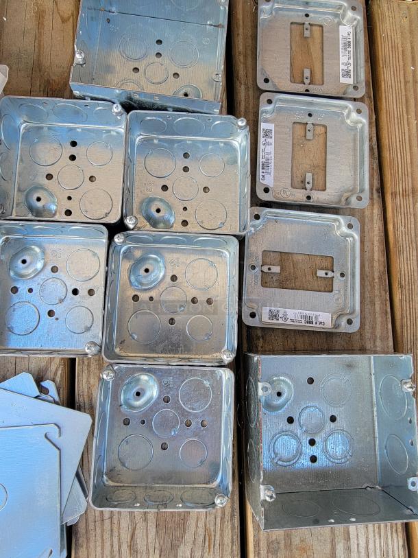 Collection of metal electrical junction boxes with circular knockouts, various shapes, and labels. Ideal for wiring projects.