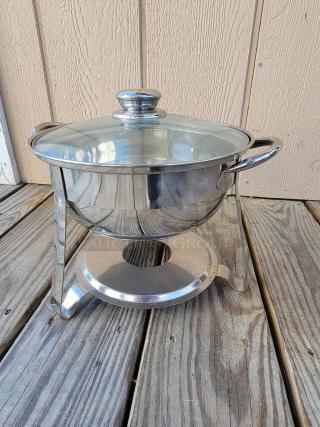 Stainless steel chafing dish with glass lid, rounded handles, elegant stand; excellent condition for stylish entertaining.