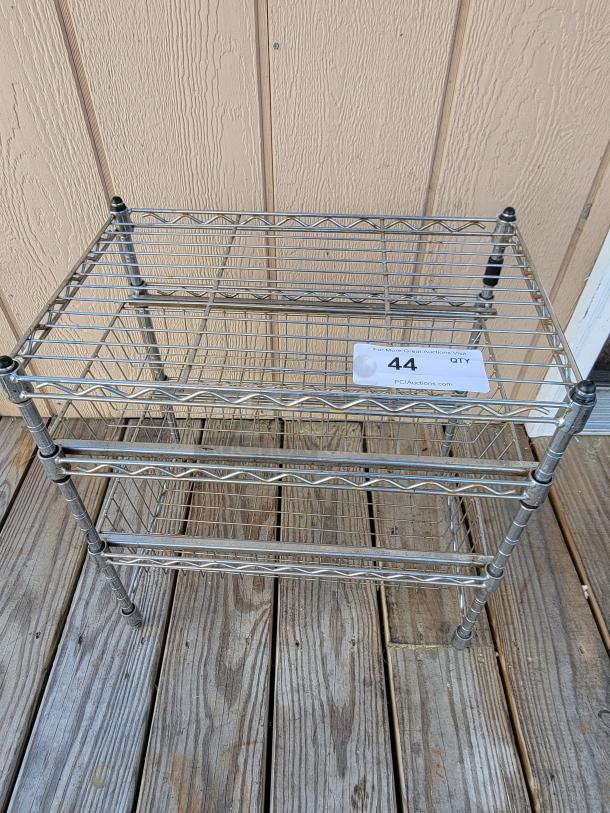 Versatile 3-tier chrome steel utility rack in good condition, ideal for storage. Includes visible auction number tag.